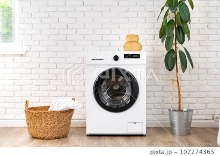 Washing machine and basket in a laundry room Washing machine and basket in a laundry room 107274365