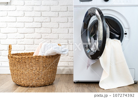 Washing machine and basket in a laundry room Washing machine and basket in a laundry room 107274392