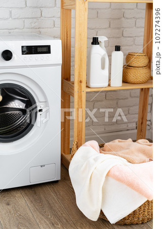 Laundry room with washing machine and basket with laundry Laundry room with washing machine and basket with laundry 107274396