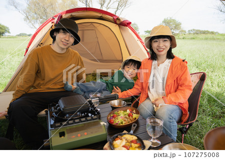 キャンプ料理を楽しむ家族・アウトドアイメージ 107275008