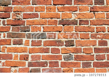 Textured wall made of red burnt brick. Ancient religious buildings 107278553
