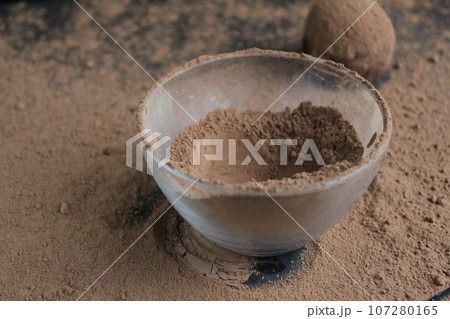 chocolate cake falls flying roll in cocoa powder. Preparation of dessert 107280165