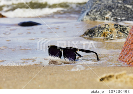 sunglasses by the sea, vacation and rest time. 107280498