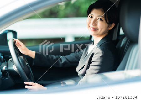 ジェケット姿で運転をする若い女性 107281334