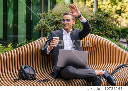 Handsome young businessman working on laptop and drinking coffee 107281424