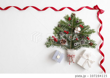 赤いリボンフレーム　クリスマスツリーとギフトボックスのイメージ　白背景 107284115