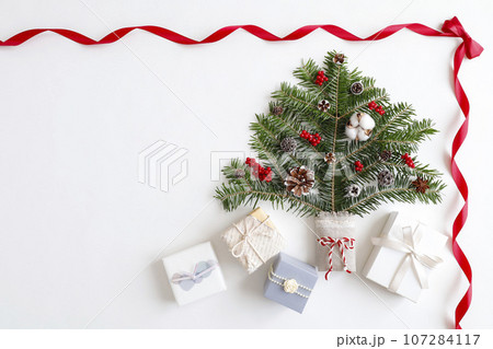 赤いリボンフレーム　クリスマスツリーとギフトボックスのイメージ　白背景 107284117