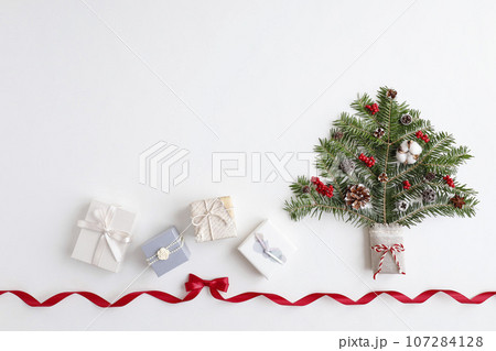 赤いリボンフレーム　クリスマスツリーとギフトボックスのイメージ　白背景 107284128