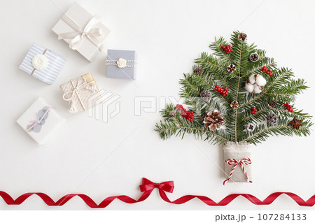 赤いリボンフレーム　クリスマスツリーとギフトボックスのイメージ　白背景 107284133