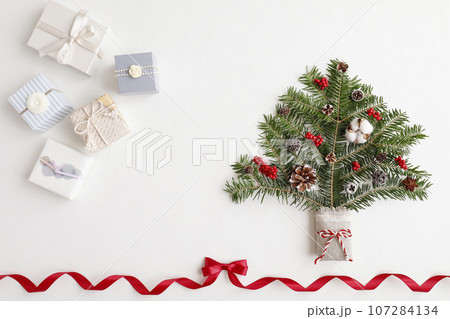 赤いリボンフレーム　クリスマスツリーとギフトボックスのイメージ　白背景 107284134