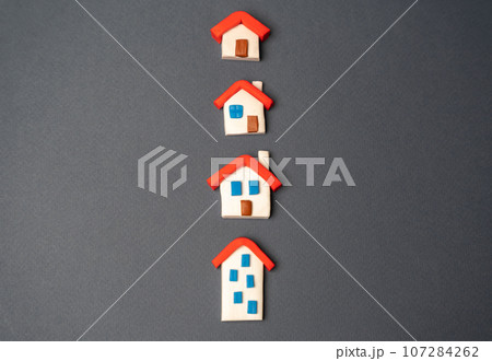 Houses figurines in a row. Find most suitable housing options. Offers on real estate market. Realtor services. Mortgage. Valuation of residential buildings. Buying and selling. Houses figurines in a row. Find most suitable housing options. Offers on real estate market. Realtor services. Mortgage. Valuation of residential buildings. Buying and selling. 107284262