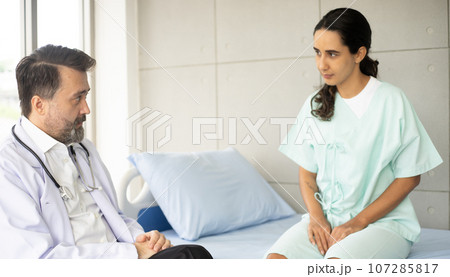 Caucasian male physician diagnosis for root cause finding with Hispanic female patient. Knee injury problem. The medical healthcare exam and check-up with the doctor concept. Caucasian male physician diagnosis for root cause finding with Hispanic female patient. Knee injury problem. The medical healthcare exam and check-up with the doctor concept. 107285817
