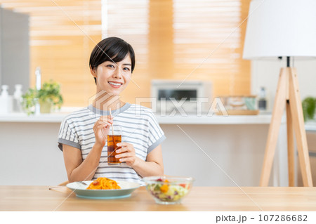 リビングで食事をしている女性。 リビングで食事をしている女性。 107286682