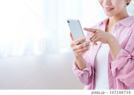 スマートフォンを操作する女性（パーツモデル） 107286739