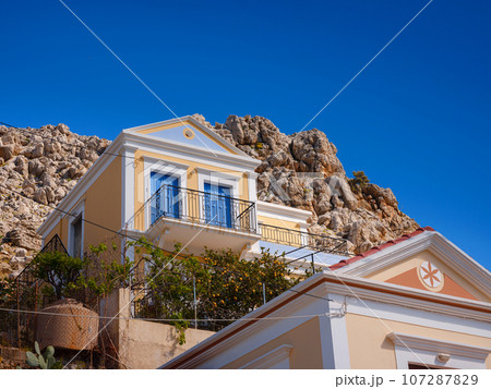 Cute details of windows, doors, balconies from old house in Simi island . Greece islands holidays from Rhodos in Aegean Sea. Colorful neoclassical houses in bay of Symi. Holiday travel background. Cute details of windows, doors, balconies from old house in Simi island . Greece islands holidays from Rhodos in Aegean Sea. Colorful neoclassical houses in bay of Symi. Holiday travel background. 107287829