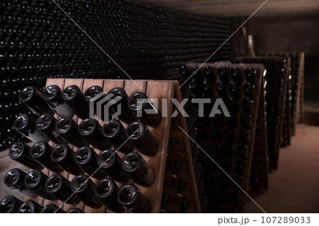 Wine bottles on racks in wine vault Wine bottles on racks in wine vault 107289033