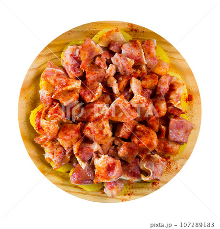 Close up of raw pig's ear with species at plate on table 107289183
