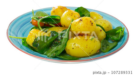 Delicious cooked fried new potatoes with spinach served at plate Delicious cooked fried new potatoes with spinach served at plate 107289331