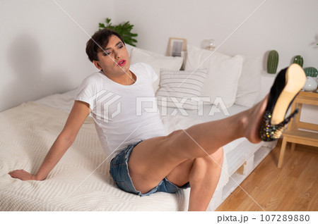 Gay trying on high heels. The guy with makeup. 107289880