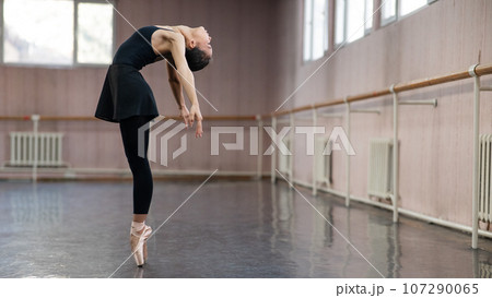 Asian woman dancing in ballet class. Bending in the back. 107290065