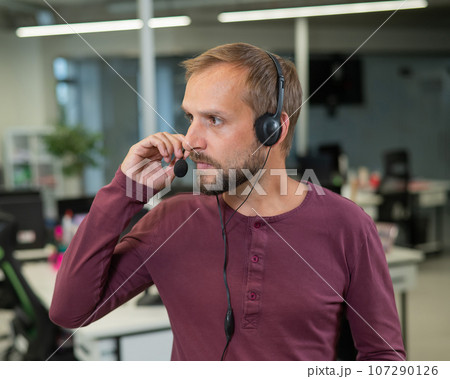 Caucasian bearded man with a headset. Male call center worker Caucasian bearded man with a headset. Male call center worker 107290126