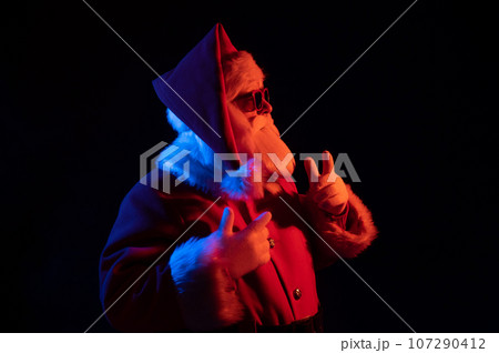 Portrait of Santa Claus in sunglasses in neon light. 107290412