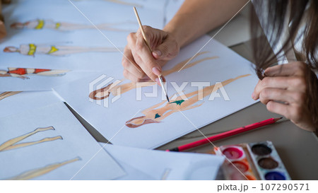 Faceless woman draws sketches of swimwear. Close-up of the hands of a fashion designer. 107290571