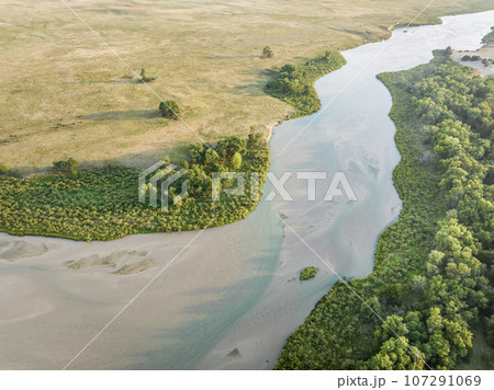 Dismal River meandering through Nebraska Sandhills at Nebraska National Forest, aerial view of late summer scenery Dismal River meandering through Nebraska Sandhills at Nebraska National Forest, aerial view of late summer scenery 107291069