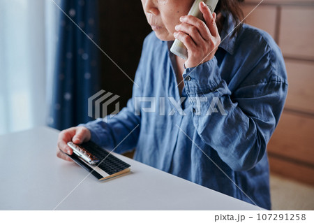 振り込め詐欺の被害に遭うシニア女性 振り込め詐欺の被害に遭うシニア女性 107291258