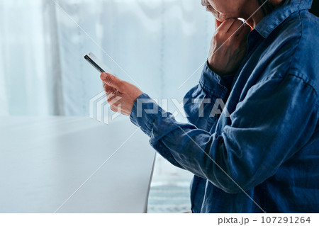 部屋でスマホを操作するシニア女性 部屋でスマホを操作するシニア女性 107291264