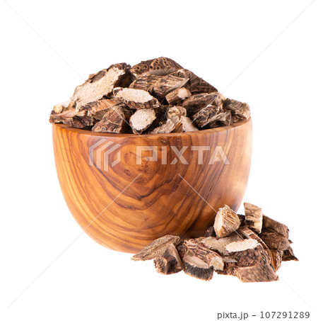 Calamus root in wooden bowl, isolated on white background. Sweet flag, sway or muskrat root. Dry root of Acorus calamus. 107291289