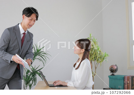 報告に来たビジネスマンと聞いている女性管理職1 107292066