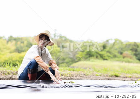 畑仕事をする若い女性 畑仕事をする若い女性 107292785