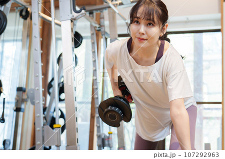ダンベルを使ってトレーニングをする女性 107292963