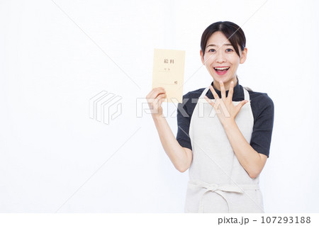 白い背景の前で給料袋を持って笑顔でおどろく30代の主婦 107293188
