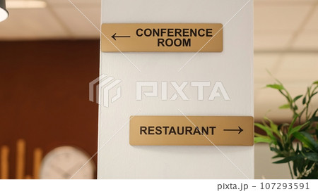 Close up of directions signs to restaurant, conference room and spa center amenities. Hotel facilities signs on travel vacation accommodation resort lounge wall, jib up shot Close up of directions signs to restaurant, conference room and spa center amenities. Hotel facilities signs on travel vacation accommodation resort lounge wall, jib up shot 107293591