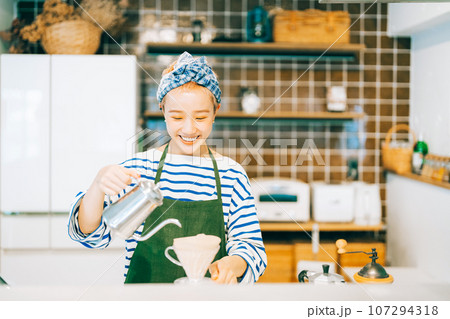 キッチンでコーヒーを淹れる女性 107294318