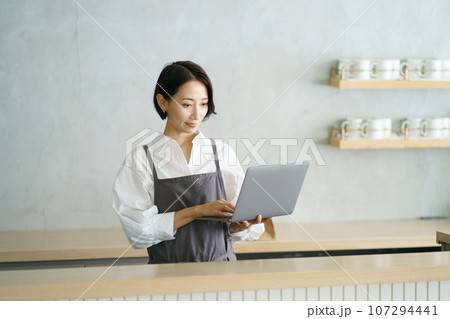 ノートパソコンを持つカフェ店員 ノートパソコンを持つカフェ店員 107294441