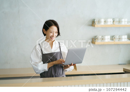 ノートパソコンを持つカフェ店員 ノートパソコンを持つカフェ店員 107294442