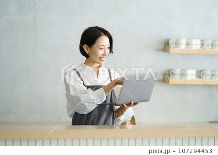 ノートパソコンを持つカフェ店員 ノートパソコンを持つカフェ店員 107294453