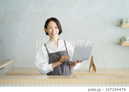 ノートパソコンを持つカフェ店員 ノートパソコンを持つカフェ店員 107294479