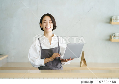 ノートパソコンを持つカフェ店員 ノートパソコンを持つカフェ店員 107294480