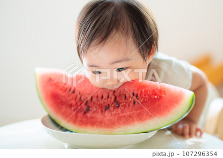 初めてのスイカにかぶりつく赤ちゃん 107296354