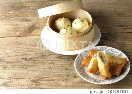 揚げ春巻きと蒸籠に入っている小籠包 揚げ春巻きと蒸籠に入っている小籠包 107297858