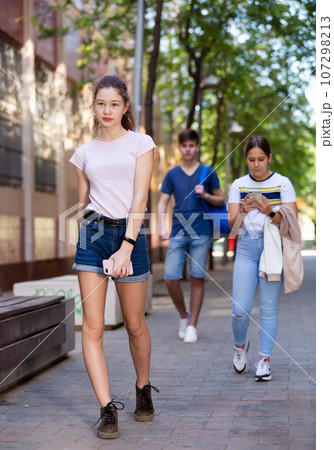 Full length portrait of teen girl walking on summer day 107298213