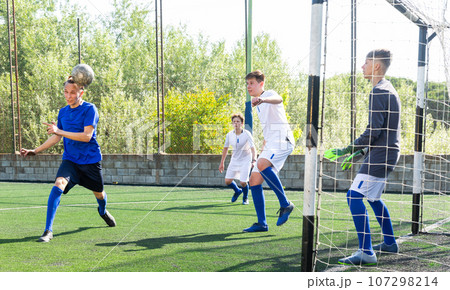 Youthful football players challenging for ball 107298214