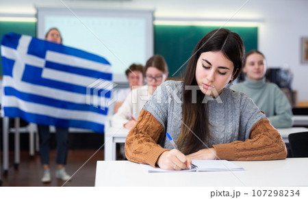 Young girl student diligently studies at school 107298234