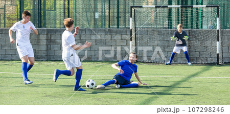 Youthful football player tackling ball Youthful football player tackling ball 107298246