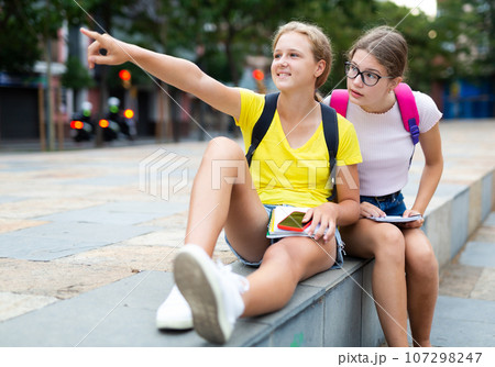 schoolgirls Two schoolgirls sitting in square and talkingの写真素材 [107298247] - PIXTA