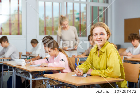Young girl studying in school with classmates Young girl studying in school with classmates 107298472
